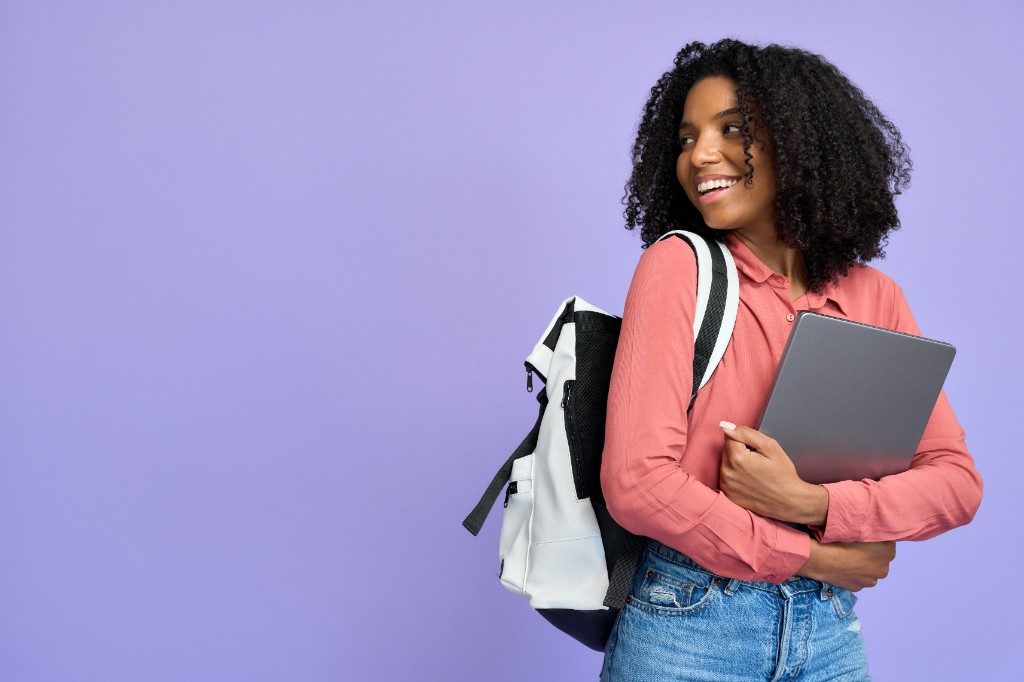 Lächelnder Student mit Laptop und Rucksack